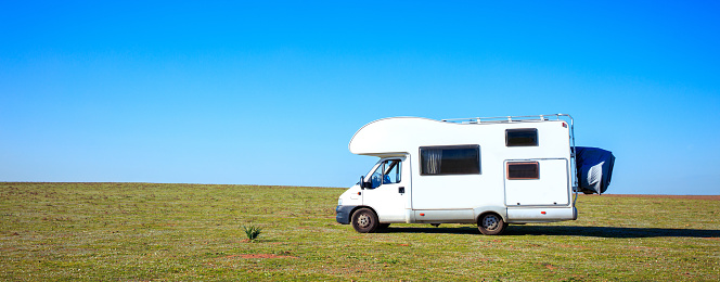 camper,  motorhome in green meadow- travel,vacation concept