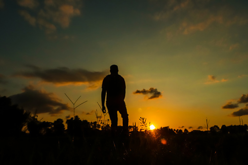 Wanderlust concept of a man standing at sunset