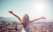 Woman with outstreched arms in front of city landscape- city life,  travel destination,active lifestyle concept