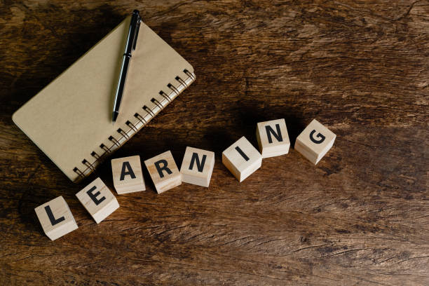 istock Wooden block cube with text LEARNING pen over notebook on wood table. business idea studying for goal. education and knowledge concept. 1632920576