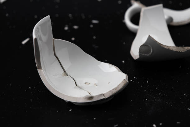 istock Large white mug with cracks. White cup for tea or soup with cracks isolated on dark background. Broken ceramic cup close up. symbol of divorce or loss 1632939465