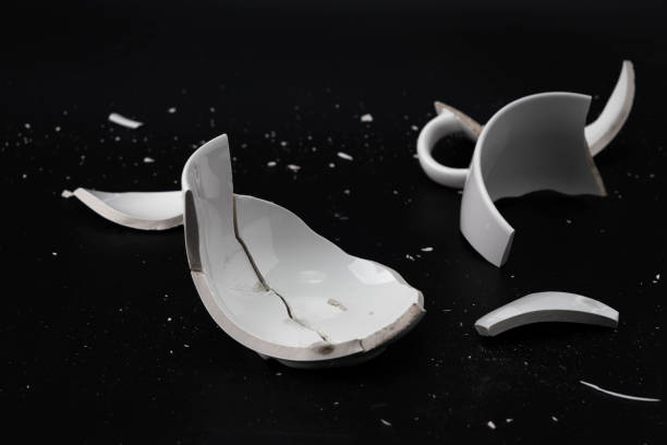 istock Large white mug with cracks. White cup for tea or soup with cracks isolated on dark background. Broken ceramic cup close up. symbol of divorce or loss 1632939986