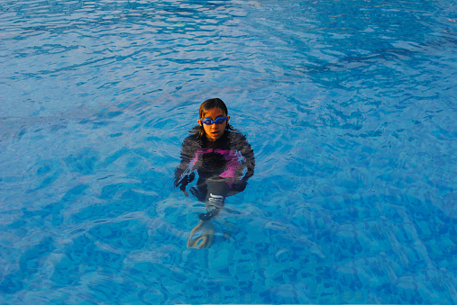 Indonesian girl is relaxing in the swimming pool while rising temperatures.