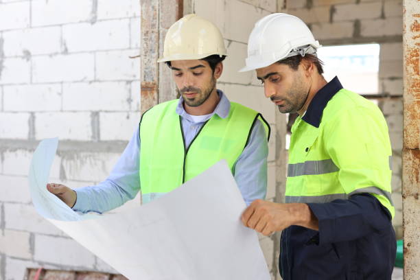 istock Two technician civil engineer or specialist inspector discussing, brainstorm and planing work with laptop, blueprint and walkie talkie radio together at Industrial building site. Construction concept 1632969791