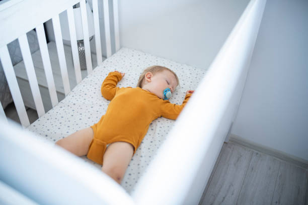 istock Baby boy laying in his crib asleep. 1632987276