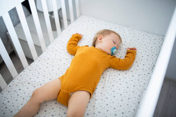istock Baby boy laying in his crib asleep. 1632987285