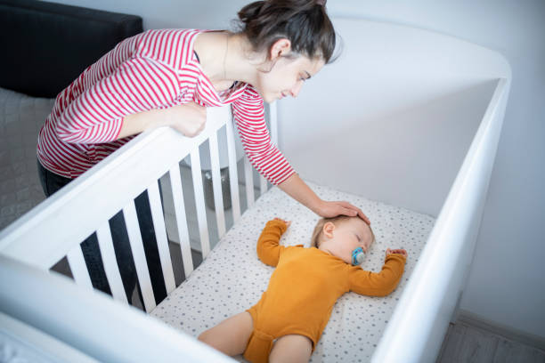istock Caring mother putting her baby boy to sleep. 1632987287