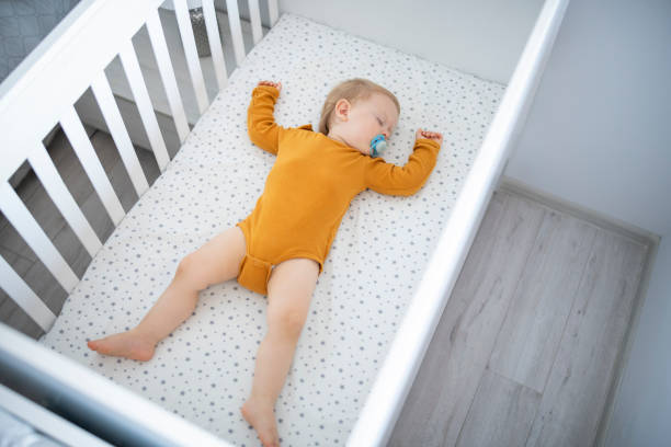 istock Cute baby boy sleeping in his crib. 1632987828