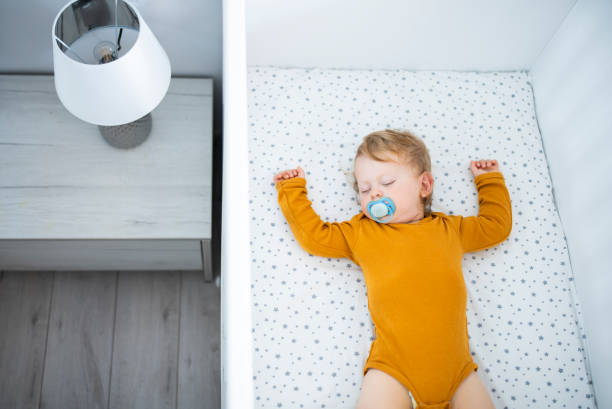 istock Cute baby boy sleeping in his crib. 1632988348