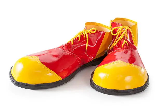 Red and yellow clown shoes isolated on white background