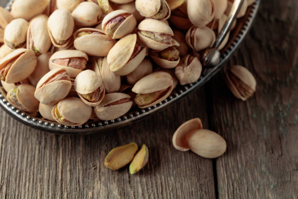 istock Salted pistachios on an old wooden table. 1632991554