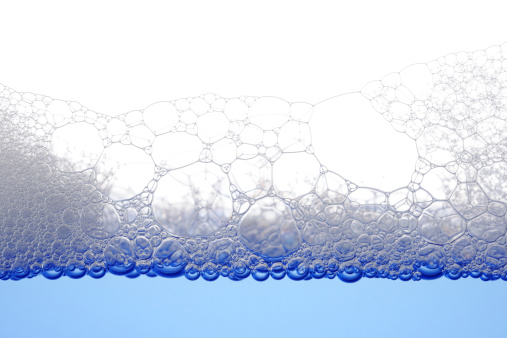 Close-up shot of soap bubbles against white background.