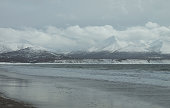 Winter sea coast with big waves and distant mountains On Iurup island