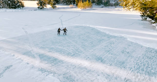 istock Couple skating on frozen lake 1633037403