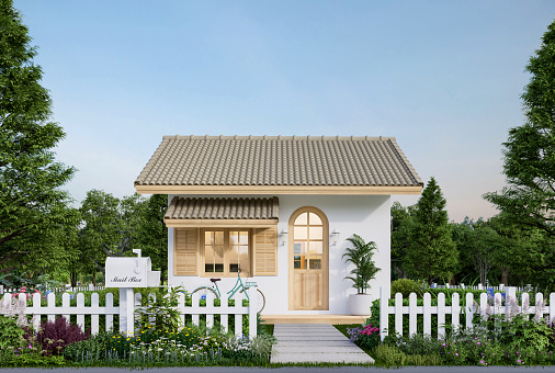 Modern contemporary cute tiny house exterior surrounded by nature 3d render There are white fence with flower bush, white wall, brown roof and wooden arch window.