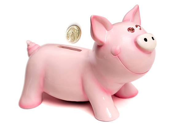 isolado cofre de porquinho rosa com moedas - piggy bank gold british currency pound symbol - fotografias e filmes do acervo