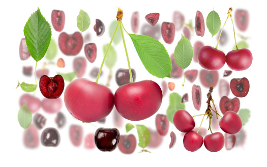 Abstract background made of Sour Cherry fruit pieces, slices and leaves isolated on white.