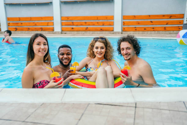 istock Young friends in swimming pool 1633144253