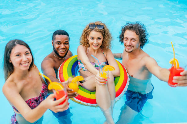 istock Young friends in swimming pool 1633147507