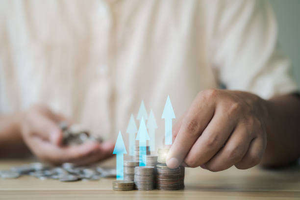 istock Businessman sorting coins higher up with an arrow pointing up Money saving concept for financial accounting to sort coins into growing graph concept. 1633150157