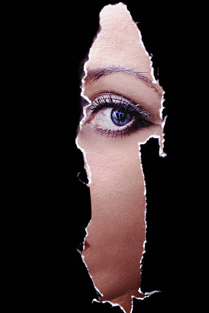 istock young woman spying through a hole in the wall 163317054