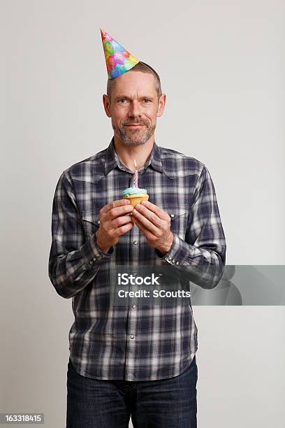 Homem Com Chapéu De Festa Segurando Bolinho - Fotografias de stock e mais imagens de 30-39 Anos - 30-39 Anos, 40-49 Anos, Adulto