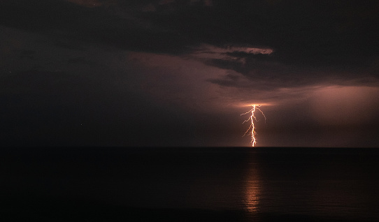 Lightning over the sea during a thunderstorm on a summer night