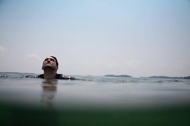 hombre treading de agua en el mar - ahogar fotografías e imágenes de stock