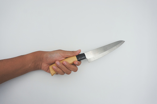 A man's hand brandishes a knife