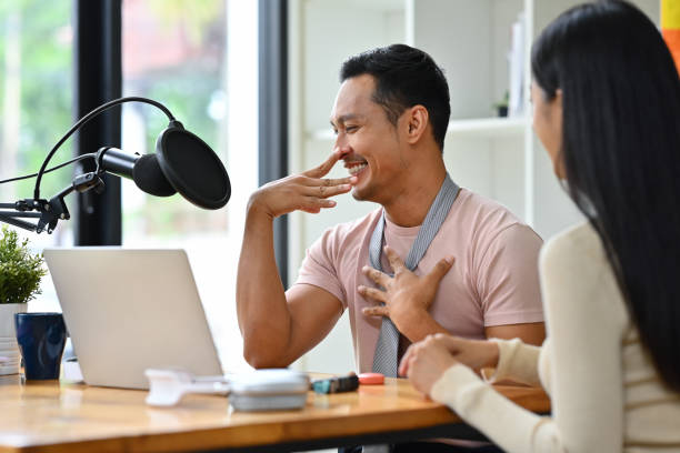 alegre presentador de radio gay discutiendo varios temas con el invitado mientras transmite podcast de audio en vivo desde el estudio - gay pride flag audio fotografías e imágenes de stock