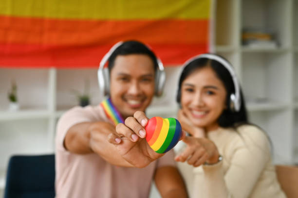 manos masculinas y femeninas sosteniendo el corazón del arco iris a la cámara. lgbtq, derechos humanos e igualdad social - gay pride flag audio fotografías e imágenes de stock