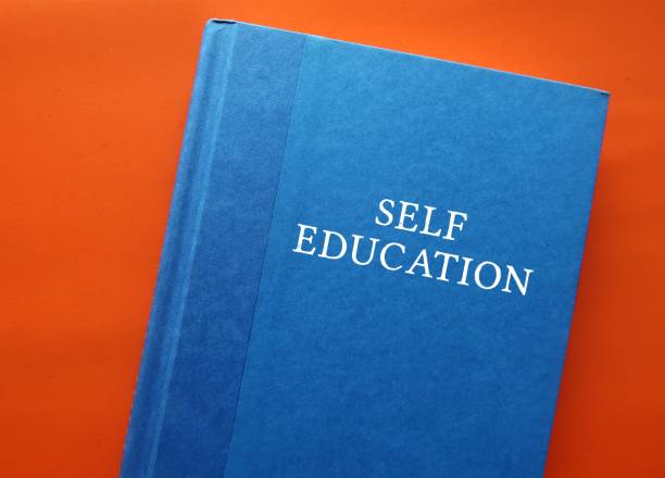 Blue text book on orange background with title text SELF EDUCATION - process of educating oneself on own efforts by reading or informal study, gaining knowledge or skill without having someone else to teach libro de texto azul sobre fondo naranja con texto del título autoeducaciÓn: proceso de educarse a sí mismo en sus propios esfuerzos mediante la lectura o el estudio informal, la adquisición de conocimientos o habilidades sin tener a alguien más a quie