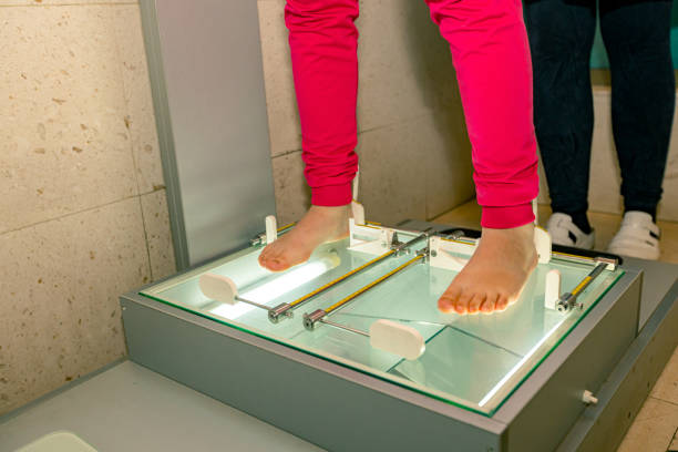 Child is at examining feet by using Plantoscopy in medical office.