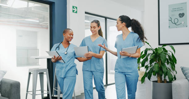 istock Talking nurses, walking and documents in hospital teamwork, diversity collaboration or bonding on surgery or clinic break. Smile, happy and healthcare women with medical research, paper or funny joke 1633320195