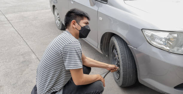 istock Driver man inflating car tire, check to raise the pressure, compressor and maintain wheels inflate 1633330434
