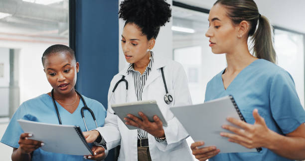 istock Doctors, nurses or women on tablet, documents or paper in diversity meeting, help collaboration or hospital teamwork. Talking, healthcare or workers on technology, surgery research or life insurance 1633330968