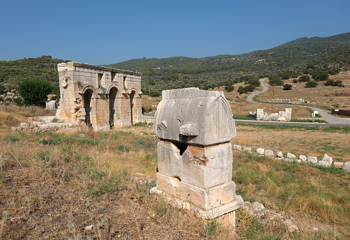 Ruins of the Patara Ancient City in Antalya, Türkiye. Patara Lycian rock tomb and city gate.
