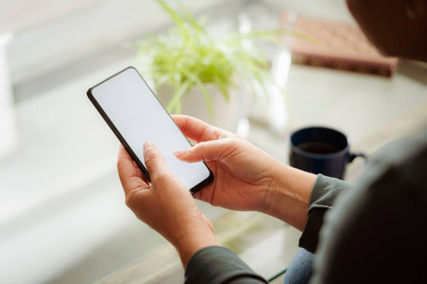 istock Close up of woman using mobile smartphone with mock up screen 1633365557
