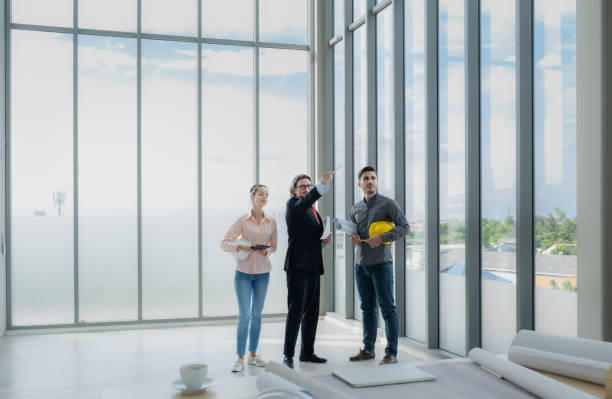 istock Engineer team meeting to inspect the construction blueprint drawings, work plan and distribute work before starting the building 1633382767