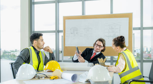 istock Engineer team is meeting to inspect the construction blueprint drawings, work plan and distribute work before starting the building 1633383881