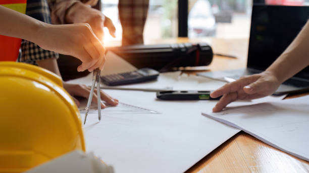 istock Construction and structure of Engineer or architect meeting for project working with partner and tools on model building and blueprint in working site 1633386120