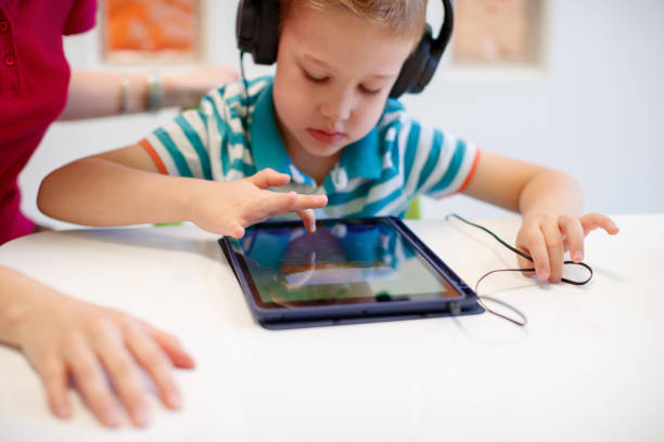 istock Preschool age boy at audiometry session, wearing headphones and using tablet 1633393986