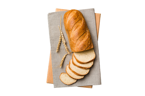Freshly baked bread slices on cutting board isolated on white background . top view Sliced bread.