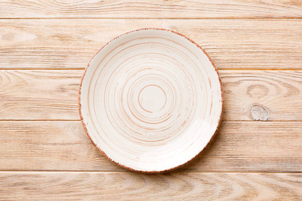 istock Top view of empty colorful plate on wooden background. Empty space for your design 1633397976