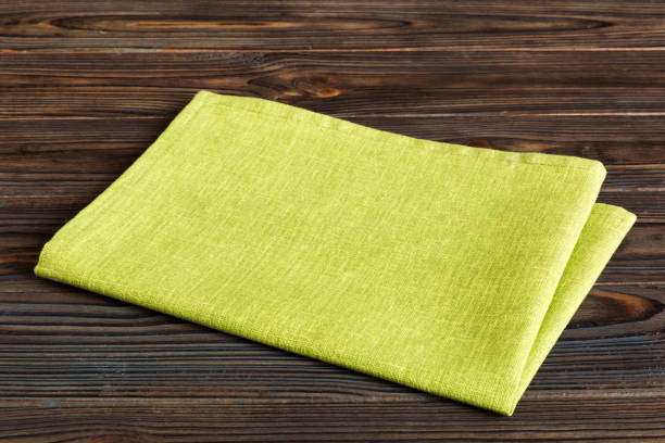 istock top view with green kitchen napkin isolated on table background. Folded cloth for mockup with copy space, Flat lay. Minimal style 1633398839