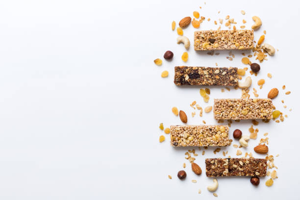 Various granola bars on table background. Cereal granola bars. Superfood breakfast bars with oats, nuts and berries, close up. Superfood concept
