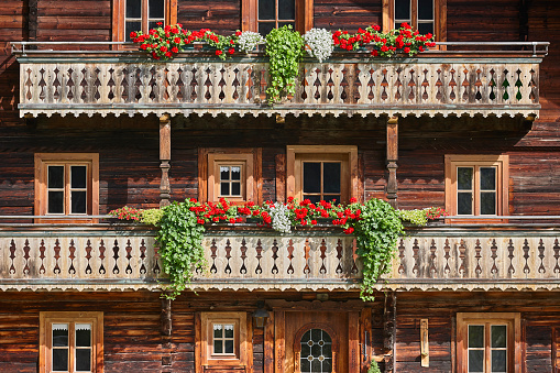 Traditional rustic wooden house decorated with flowers in Austria