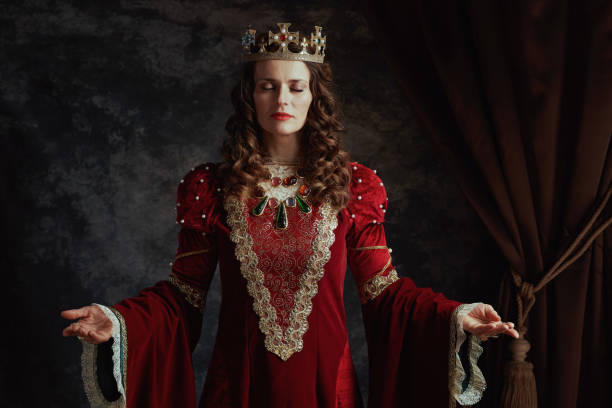 istock medieval queen in red dress with crown 1633403354