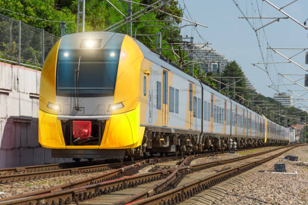istock Yellow long suburban passenger electric train rides on the railway. 1633432938