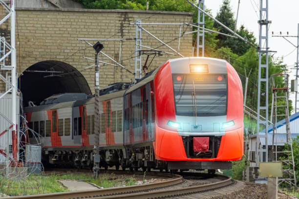 istock Passenger suburban train leaving the tunnel with headlights on. 1633434523